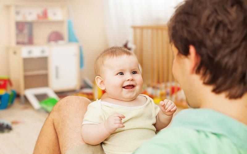 Hình ảnh trẻ 4 tháng tuổi ngồi thẳng với sự hỗ trợ, đầu giữ vững và tay với đồ vật, biểu hiện dấu hiệu sẵn sàng khi trẻ 4 tháng an dặm được chưa